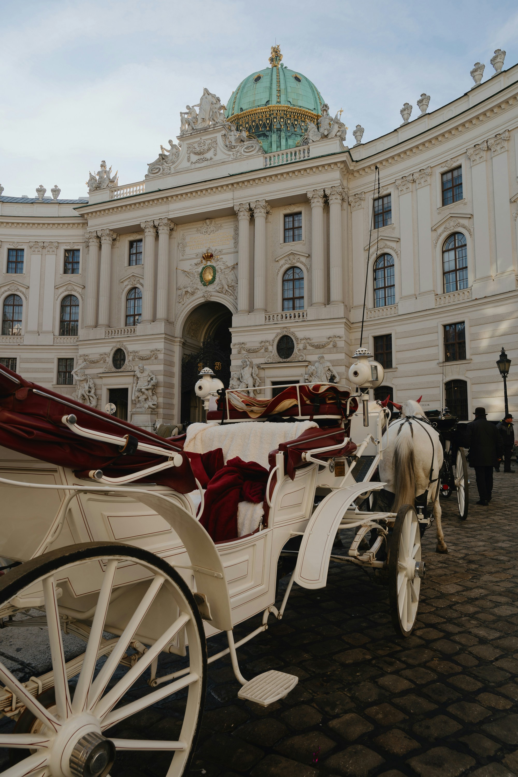 Fiacre blanc devant le palais impérial de la Hofburg à Vienne — voyage sur mesure en Autriche