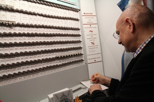 a man with glasses is writing on a paper