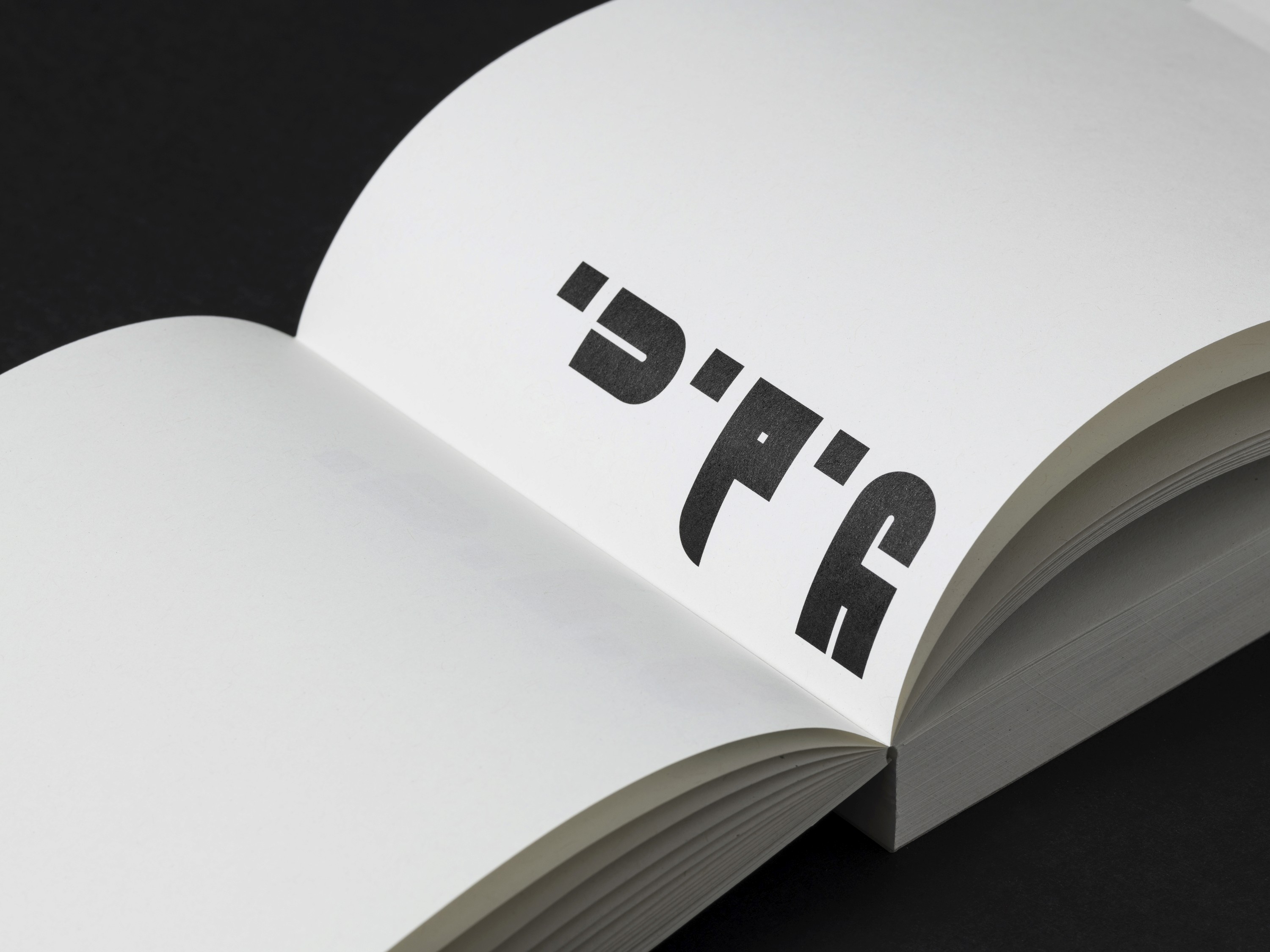 Open book showing bold typographic lettering
