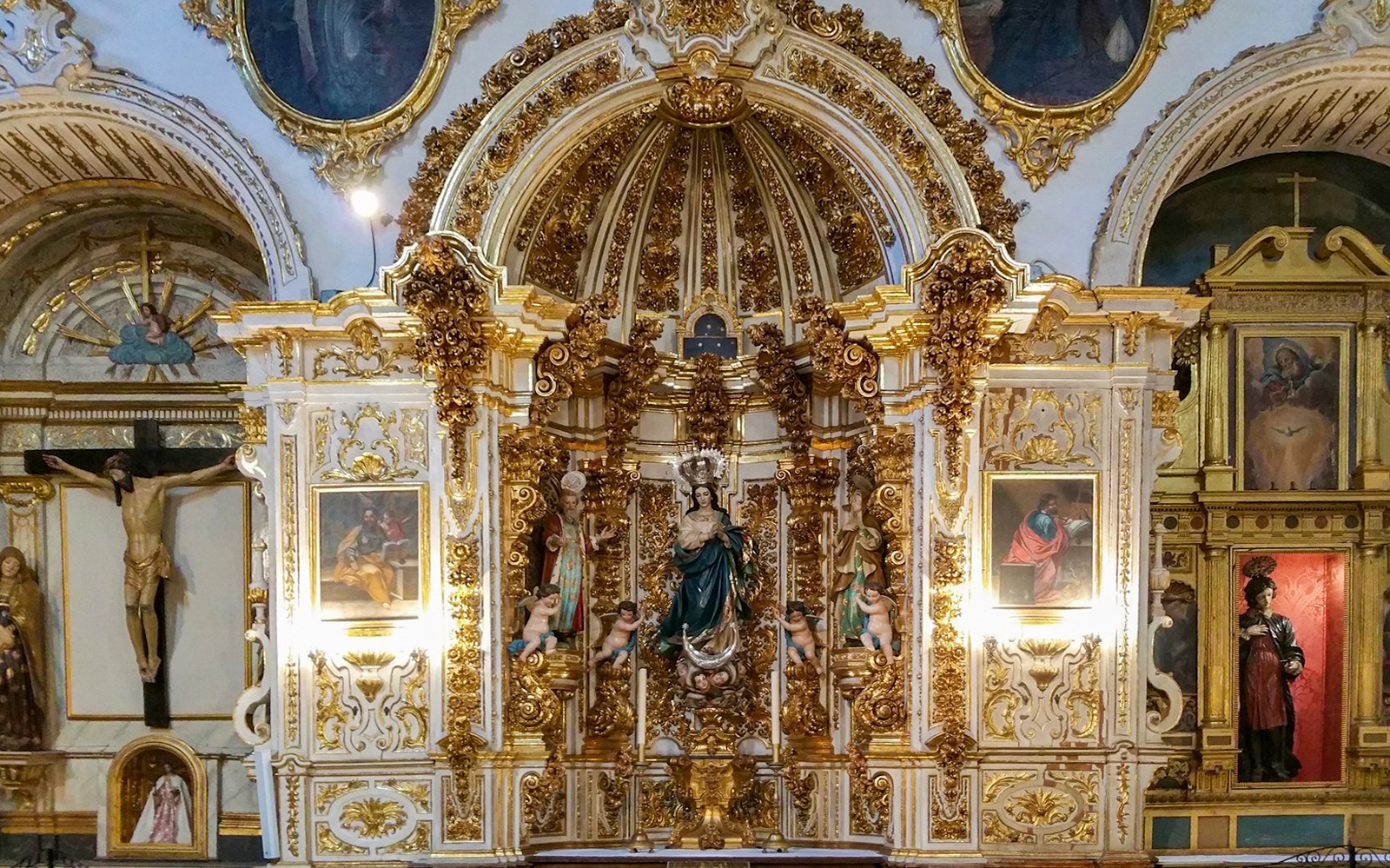 Altare ornato all'interno della Cattedrale e della Cappella Reale di Granada, con statue religiose e dettagli in oro.