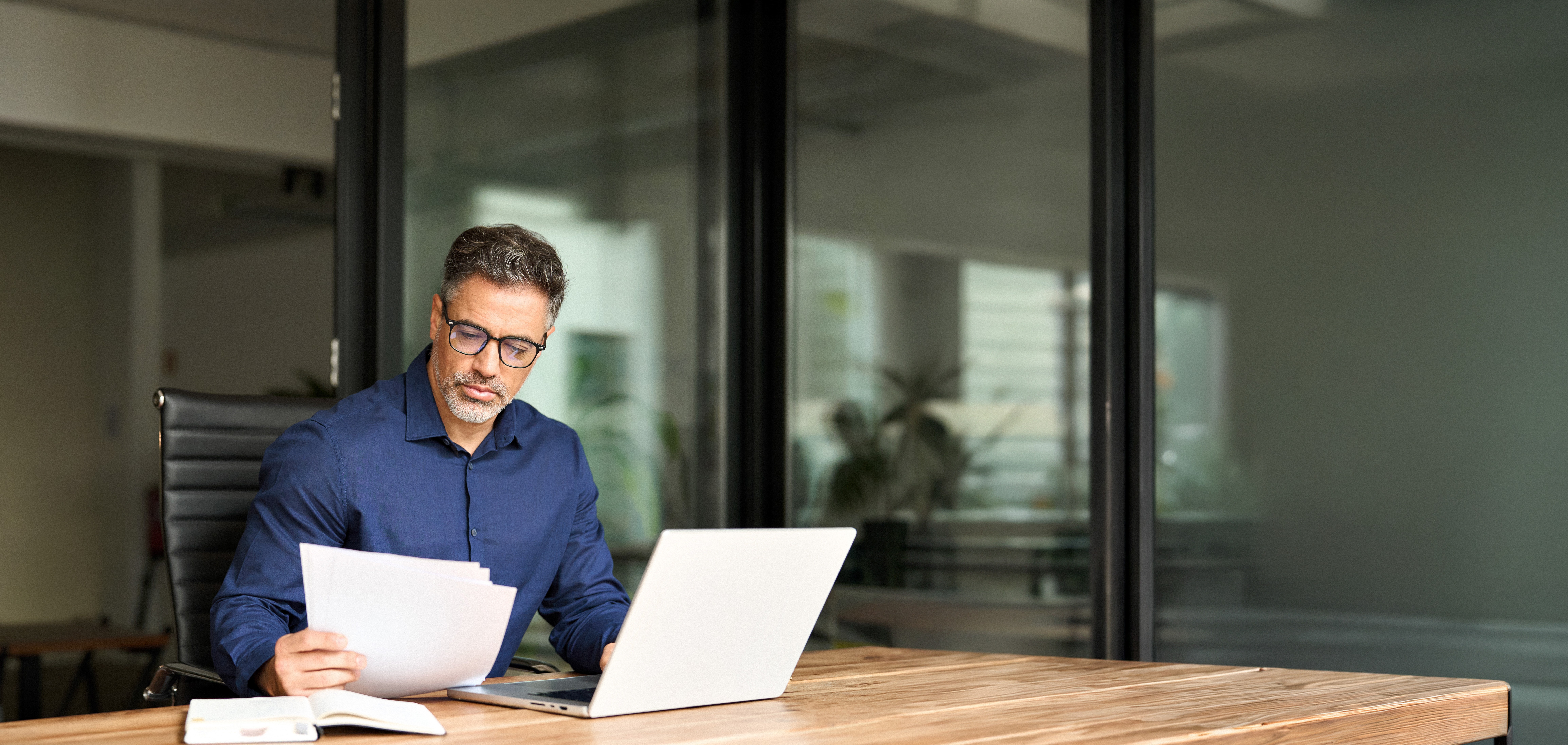 Private lender reviewing loan application documents at office desk