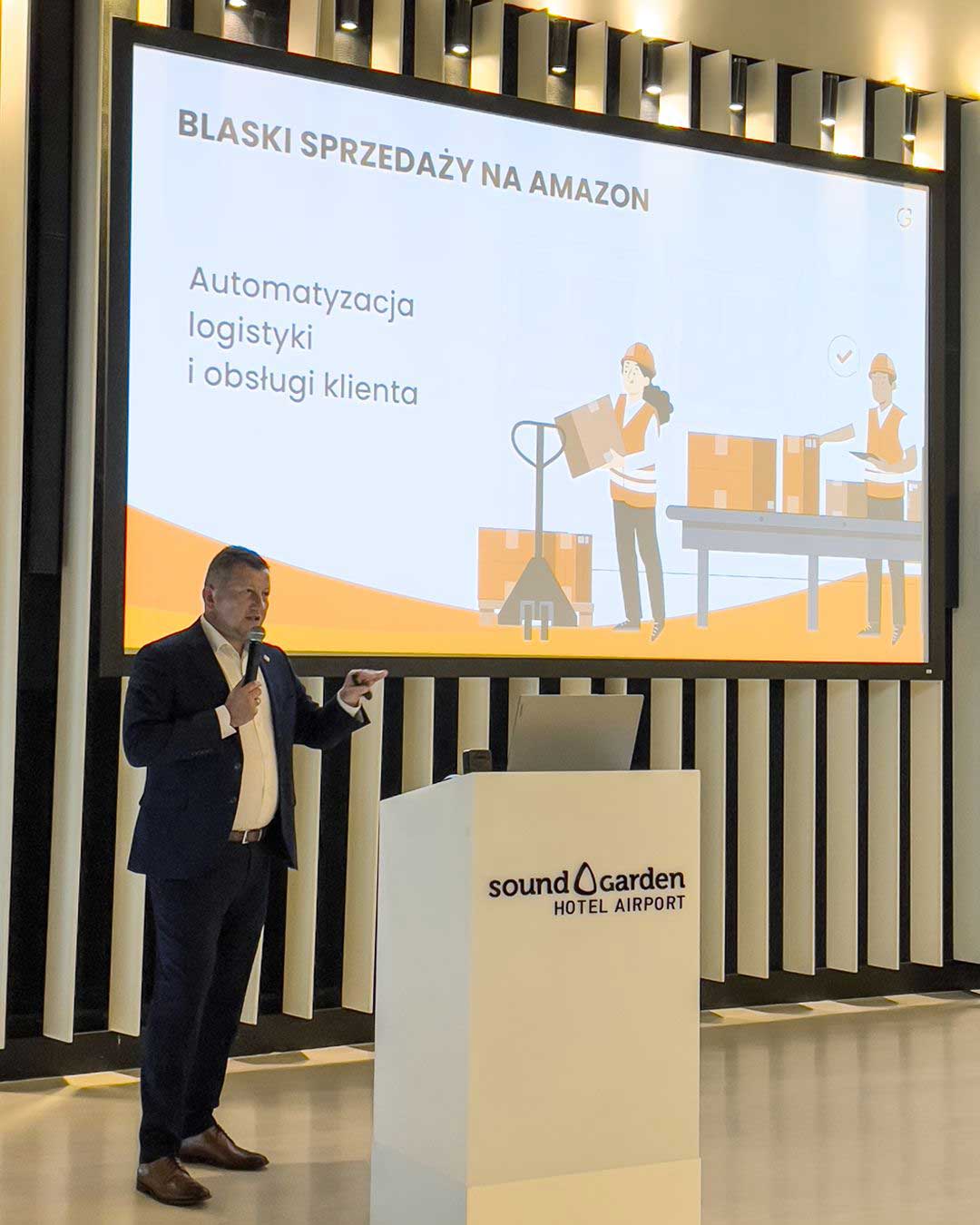 Prezentacja na konferencji Go2Market z mówcą omawiającym temat automatyzacji logistyki i obsługi klienta, z wyświetlonymi ilustracjami na ekranie