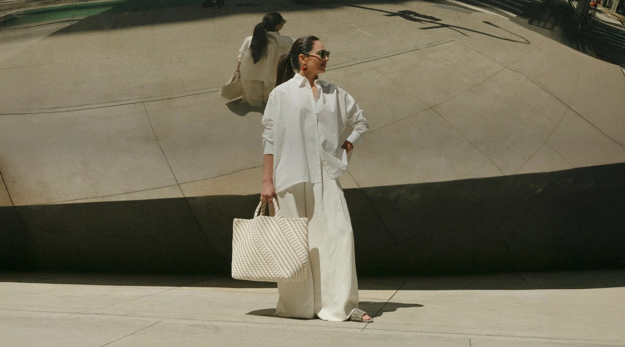 A NAGHEDI woven handbag carried on a city street