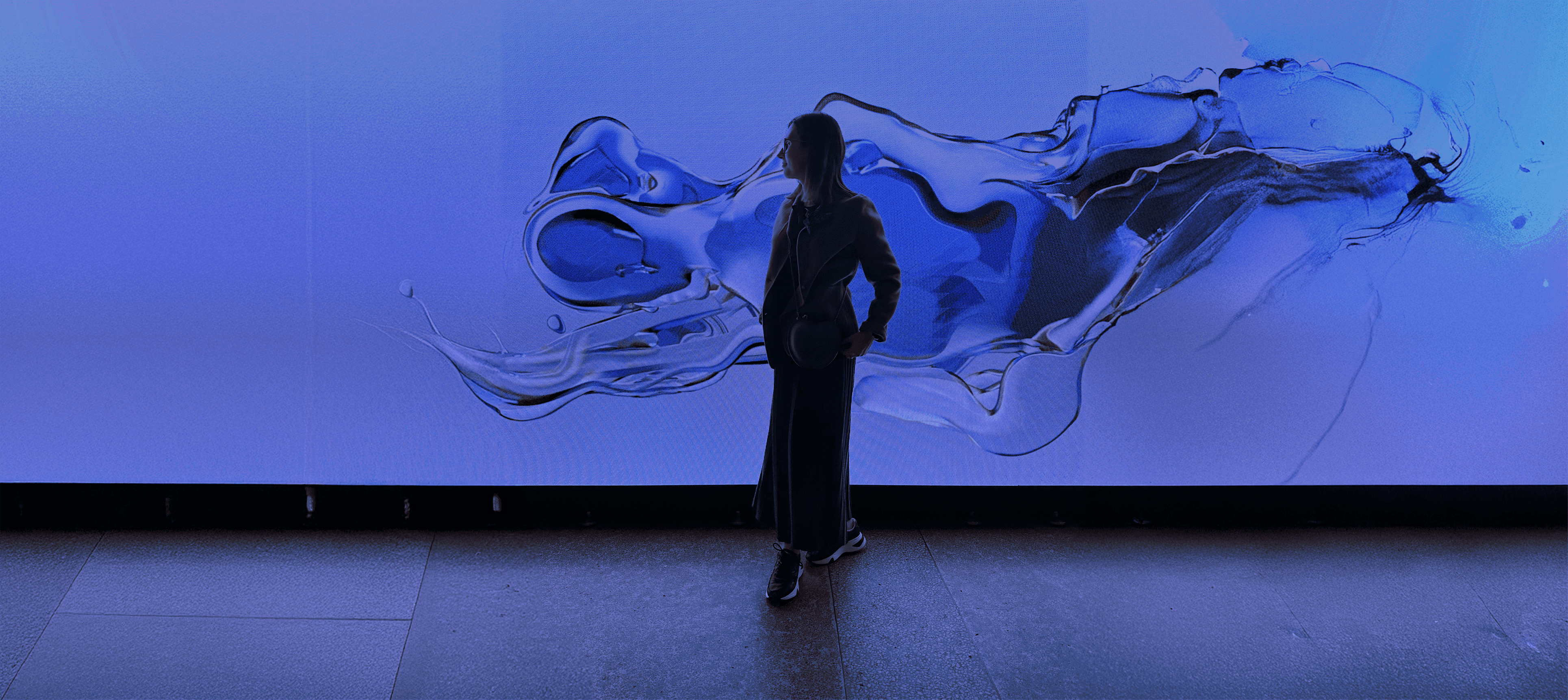 A silhouette of a person wearing sunglasses, with tousled hair, against a teal background.