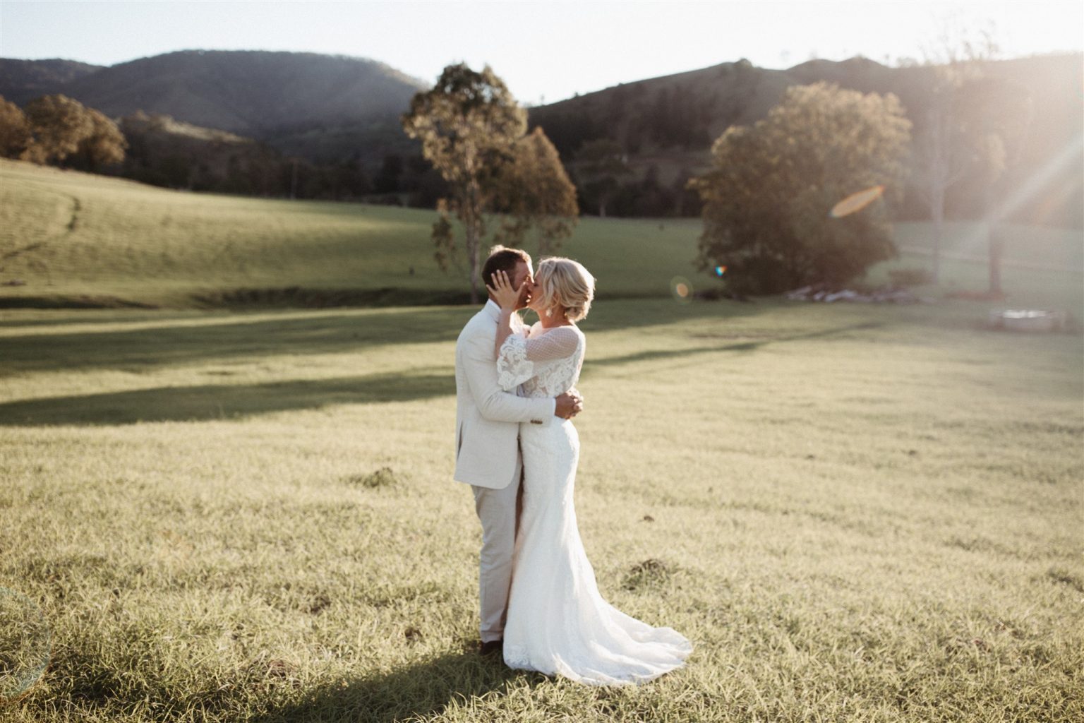 Bride & Groom kissing in a field