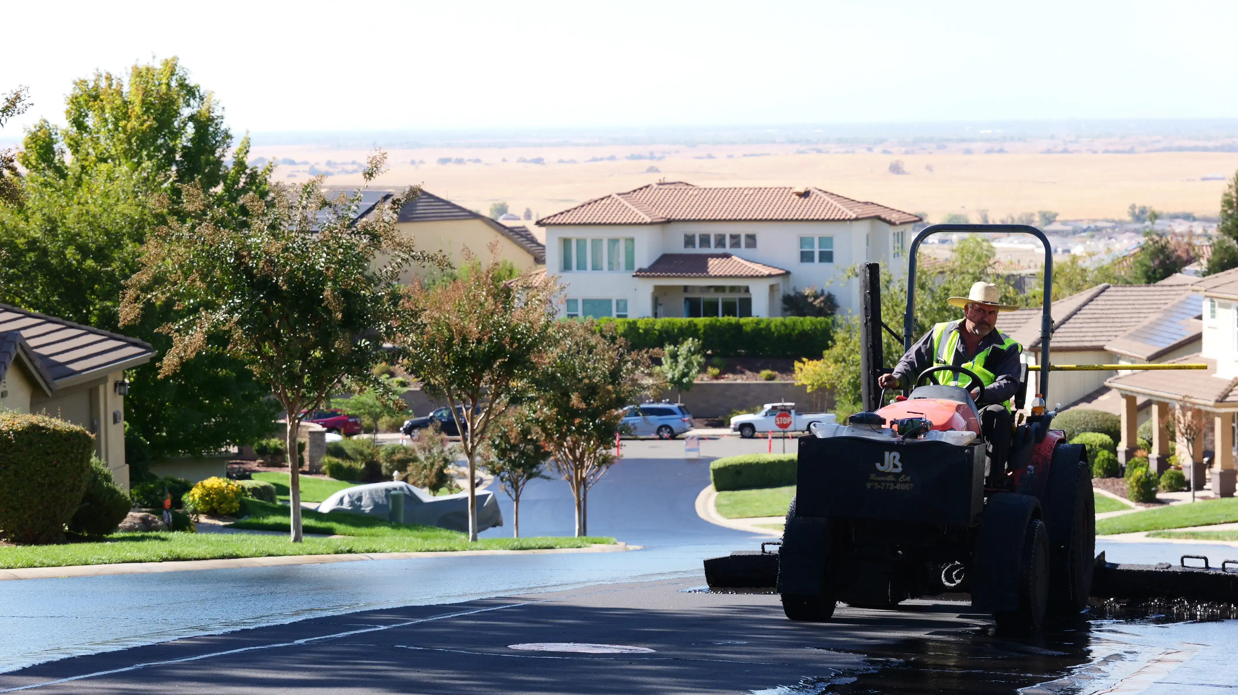 Closeup photo of seal coat squeegee tractor on project