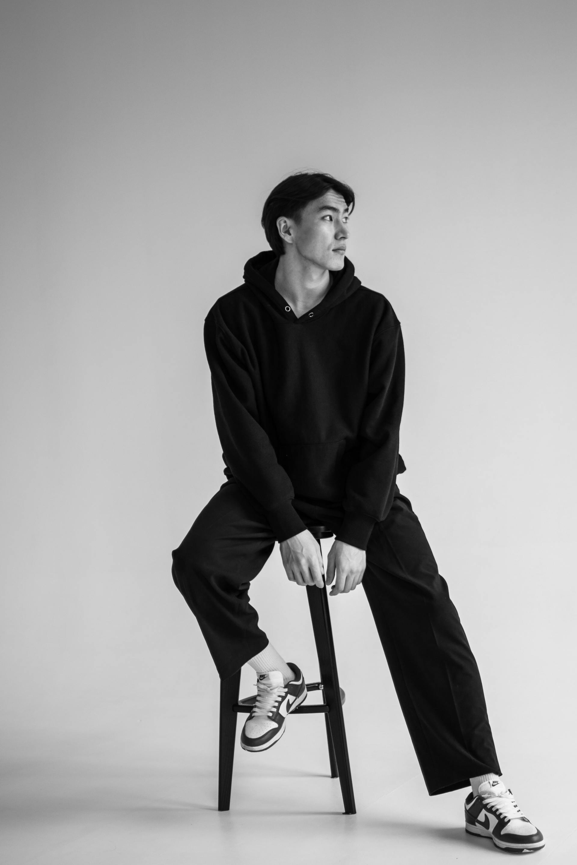 Stylish Man in Black Outfit Sitting on Stool