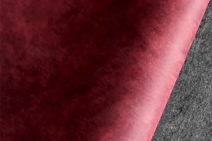 Hand cutting brown leather with precision knife on green cutting mat – leather crafting process