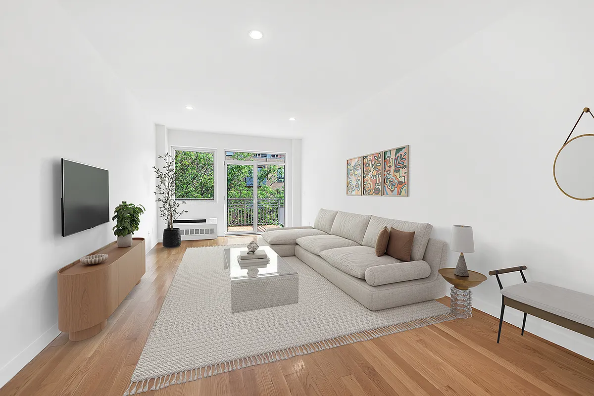 A bright living room featuring white walls and warm wooden floors, creating a cozy and inviting atmosphere.