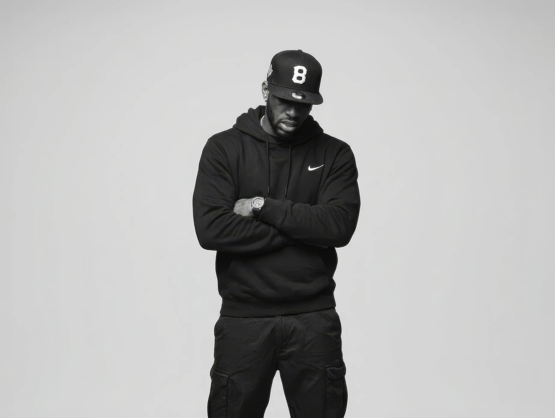 Black and white portrait of London music artist Skayze Daze standing with arms crossed against a plain backdrop.