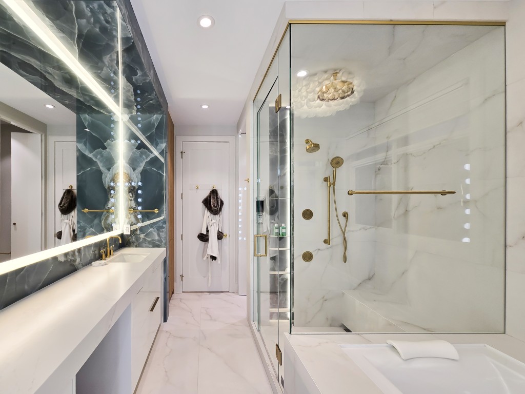 Image of Luxurious primary ensuite bathroom with marble design, gold fixtures, and modern layout by KHD Homes.