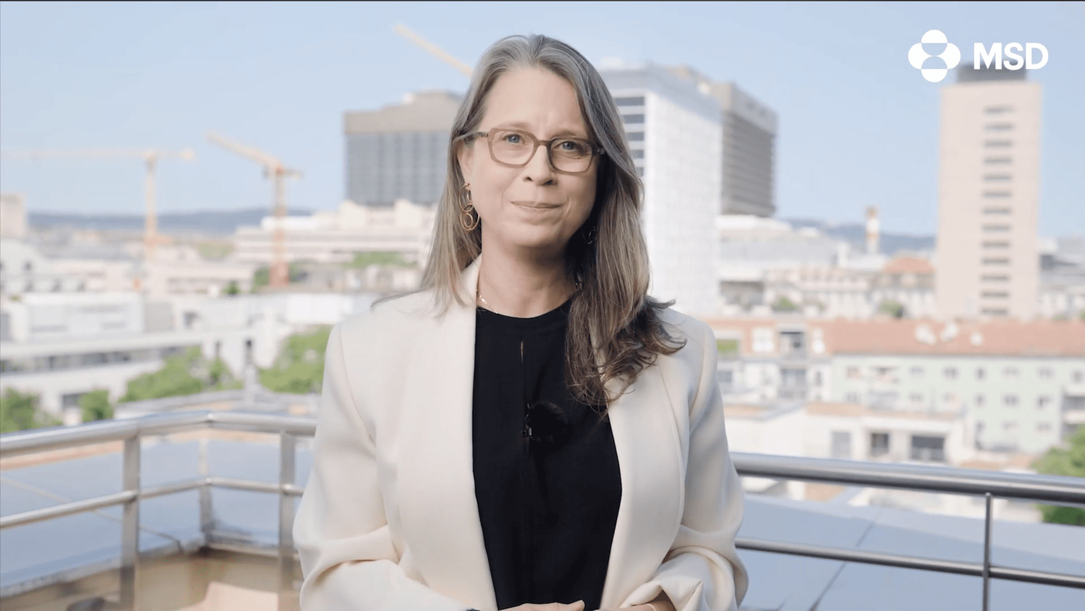 Picture showing Nicole Schlautman CEO of MSD Austria standing on a rooftop tearace overlooking the AKH