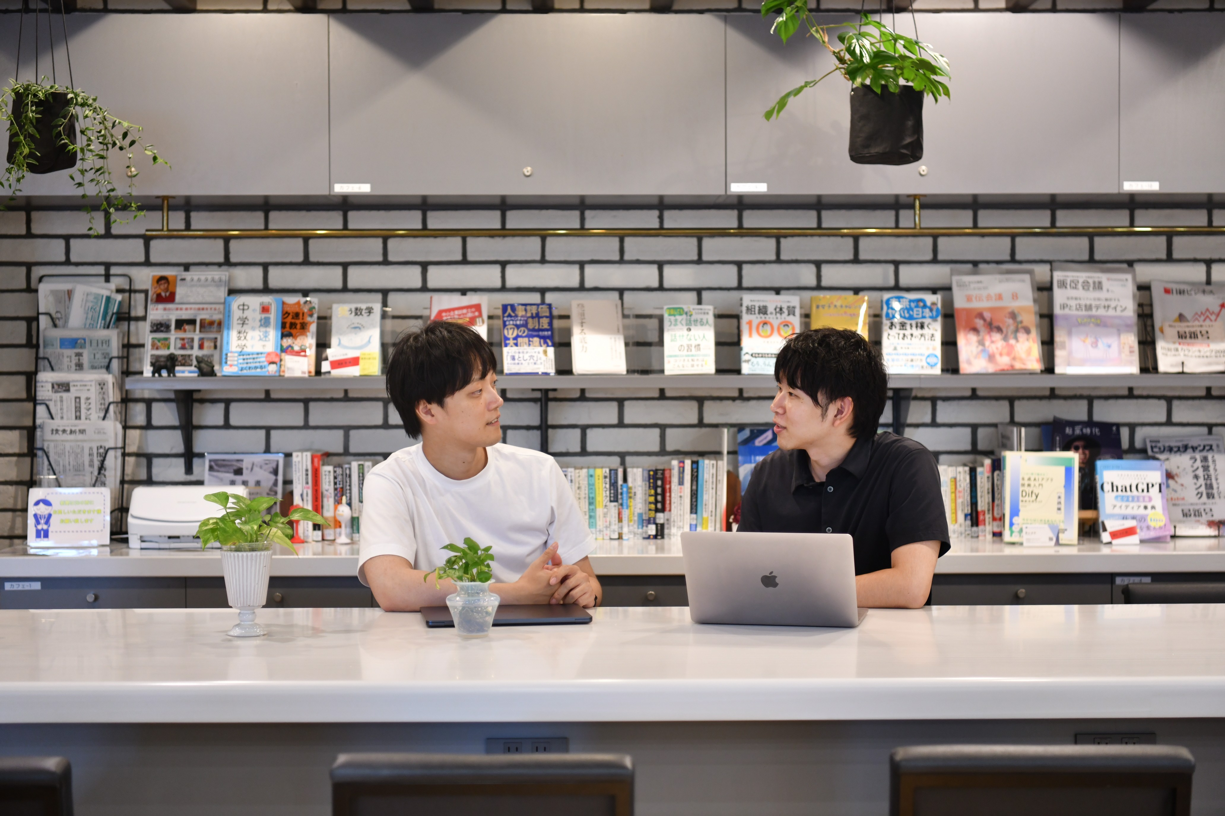LeapWellメンバーがオフィスのカウンターでノートPCを囲んで対話する様子