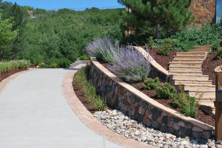 retaining wall with stone and wood, a flat on the side leading to stairs going into landscape design, lavender plants, shrubs