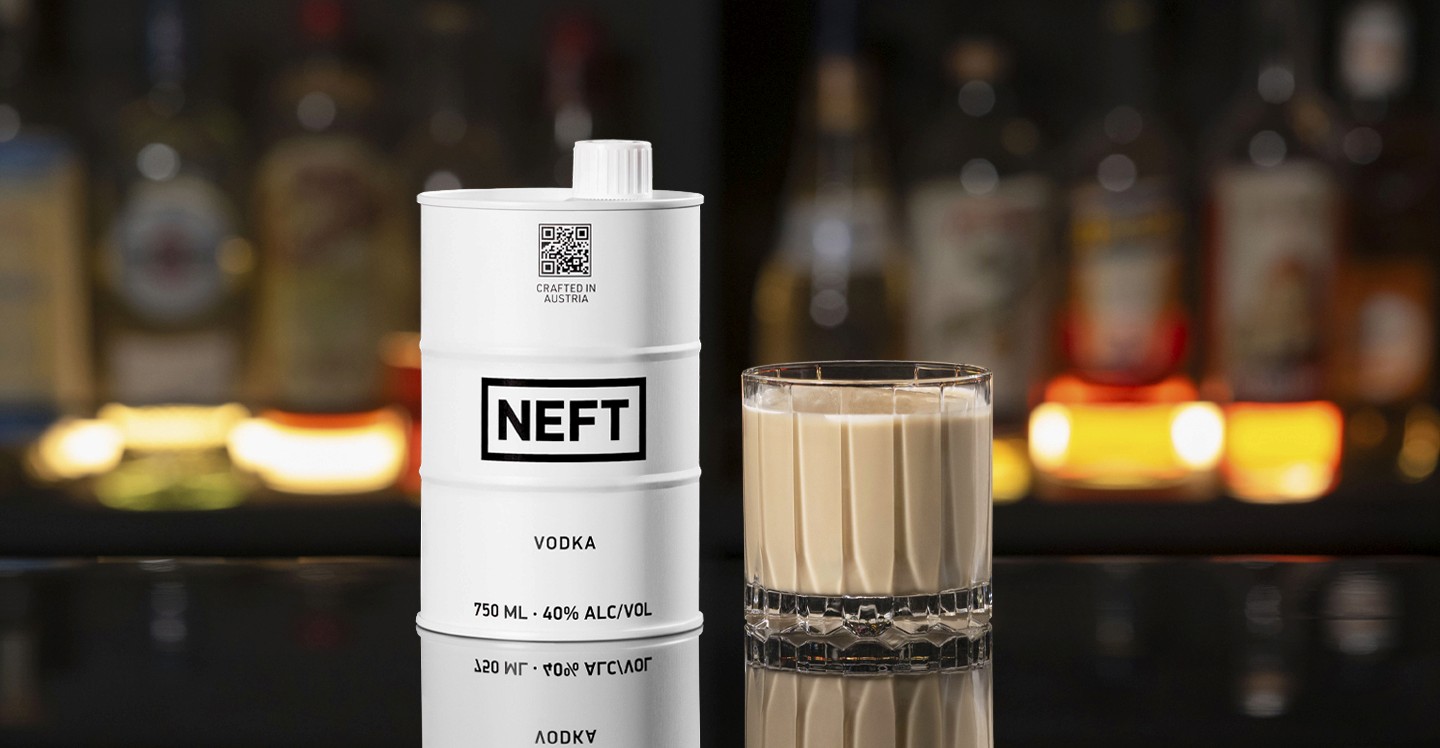 A NEFT Barrel and a glass of White Russian on a bar counter.