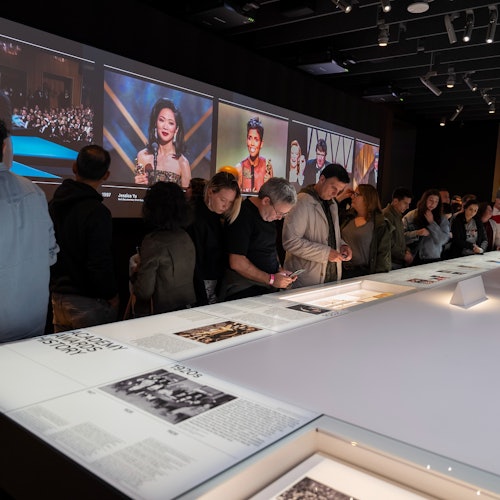 Guests observing outfits and information from the Oscars ceremony.