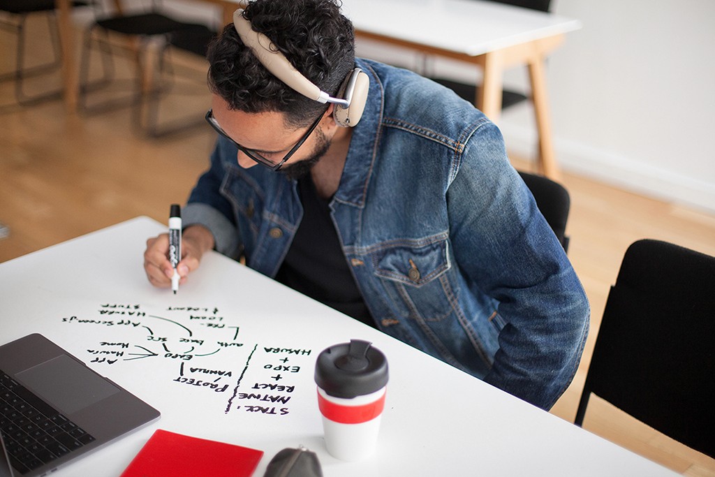 A smiling designer at a desk, comfortable in their element and ready to collaborate.