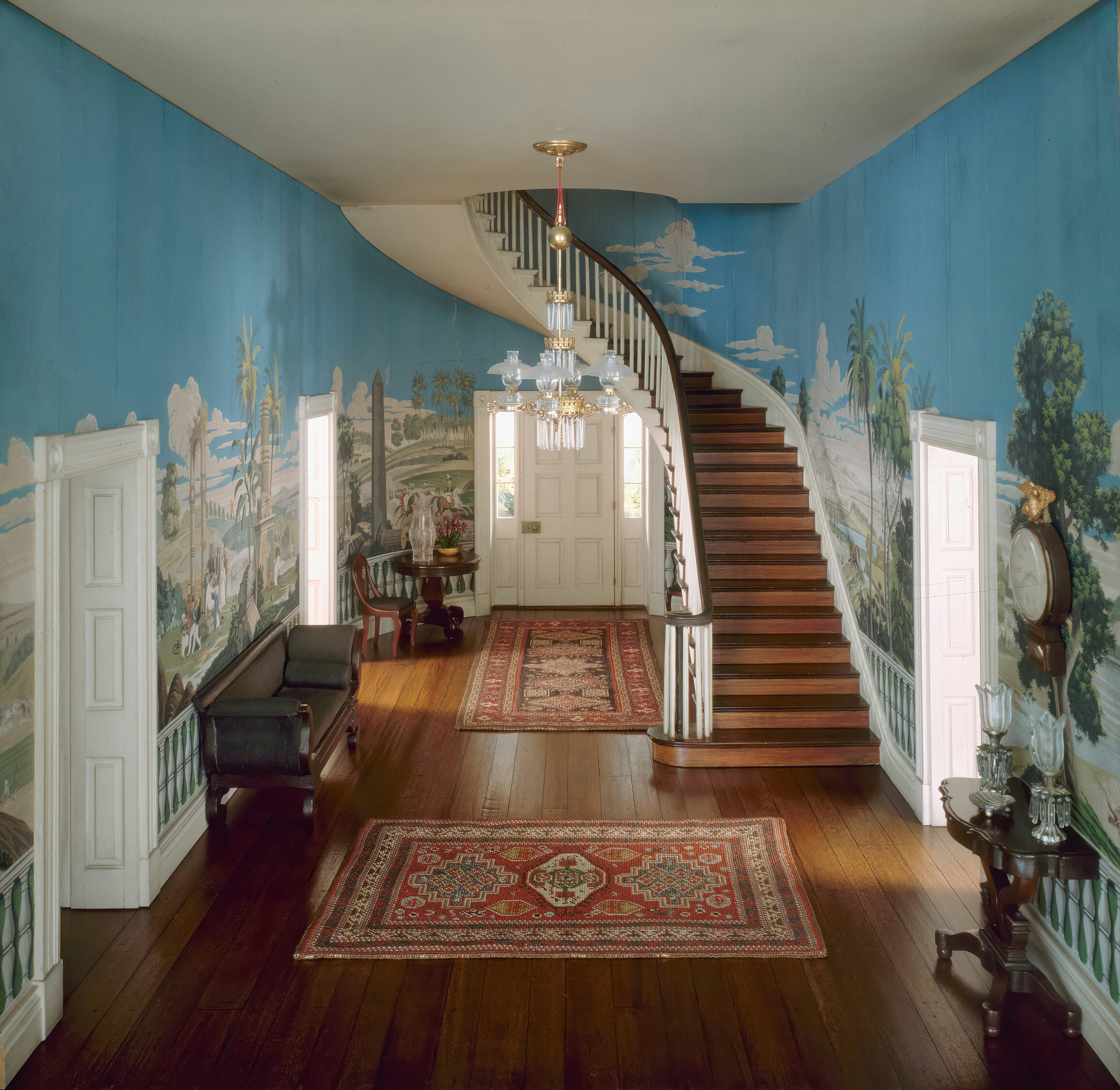 a hallway with a staircase and a painting on the wall