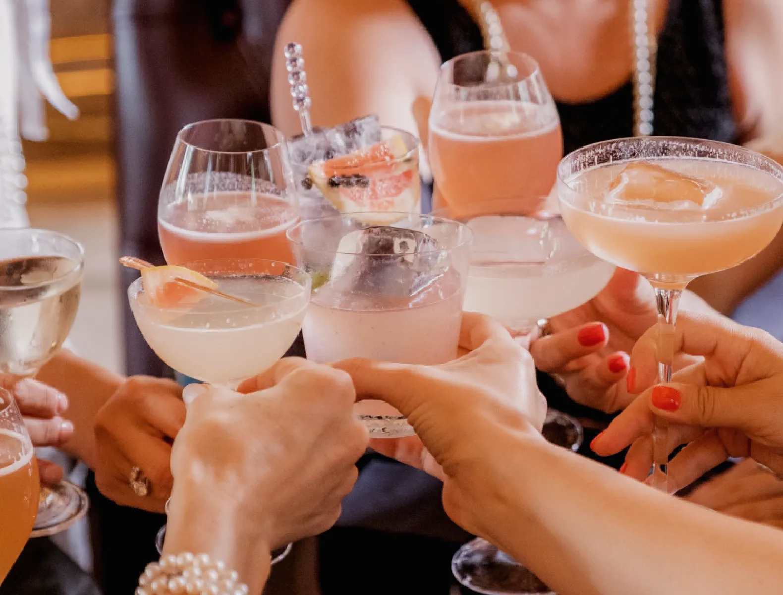 A group of people toasting their cocktails.
