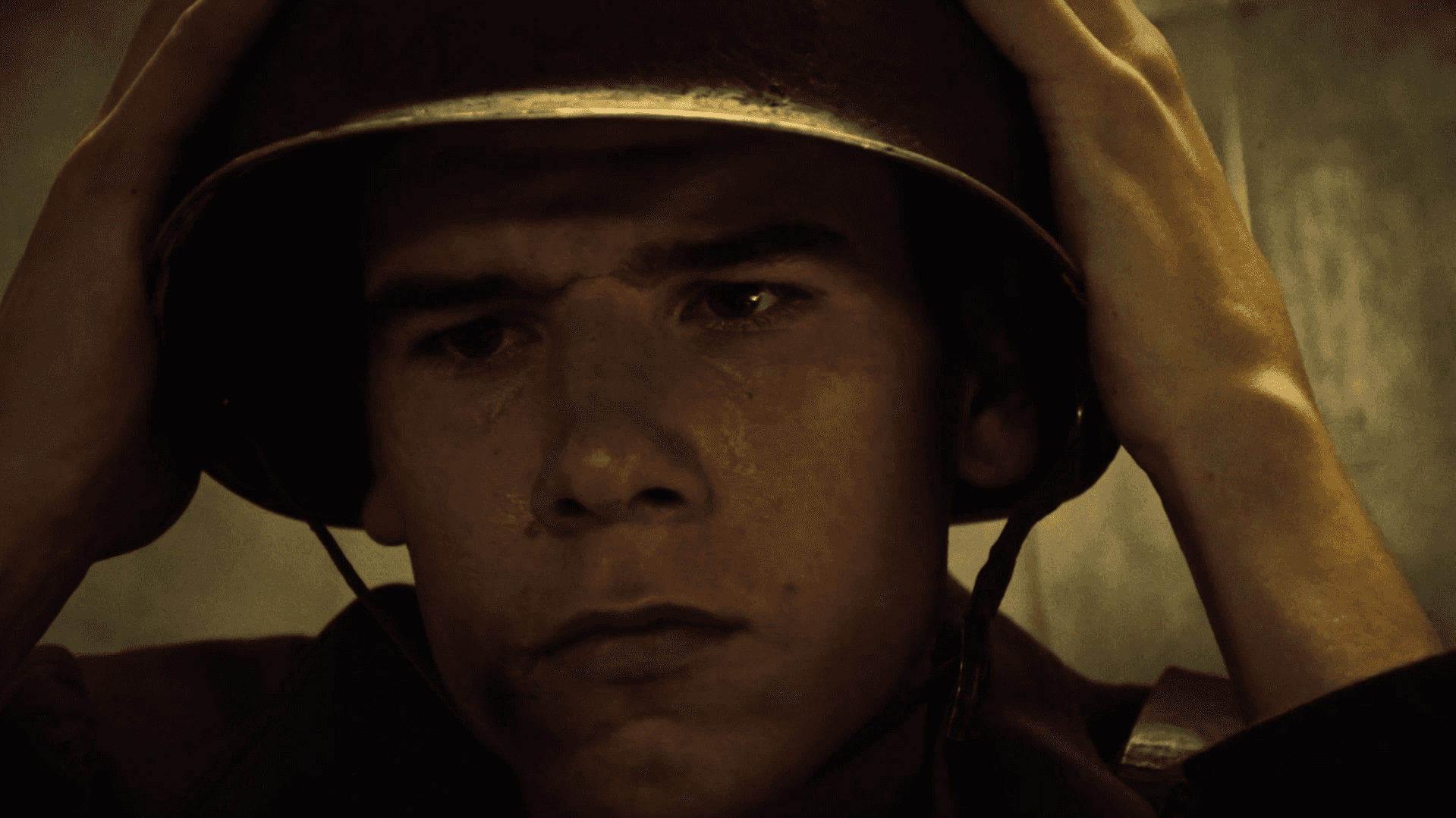 View of the French countryside through a stone villa’s open living room, with sofas and trees framing the scene