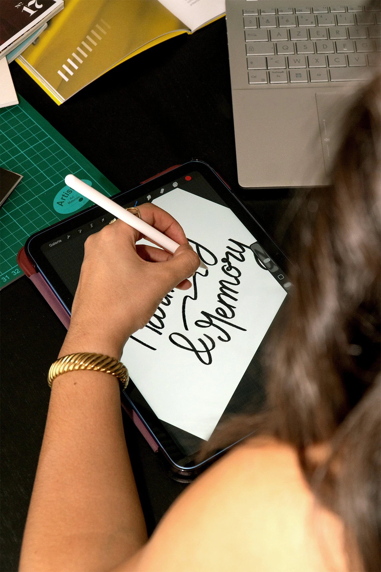 Directrice artistique dessinant un lettrage manuscrit sur tablette graphique pour le projet Harmony and Memory.