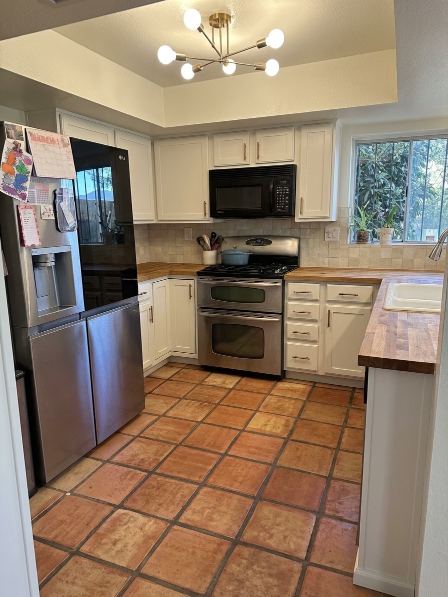 Warm white cabinets with butcher block and cream backsplash over Saltillo tile