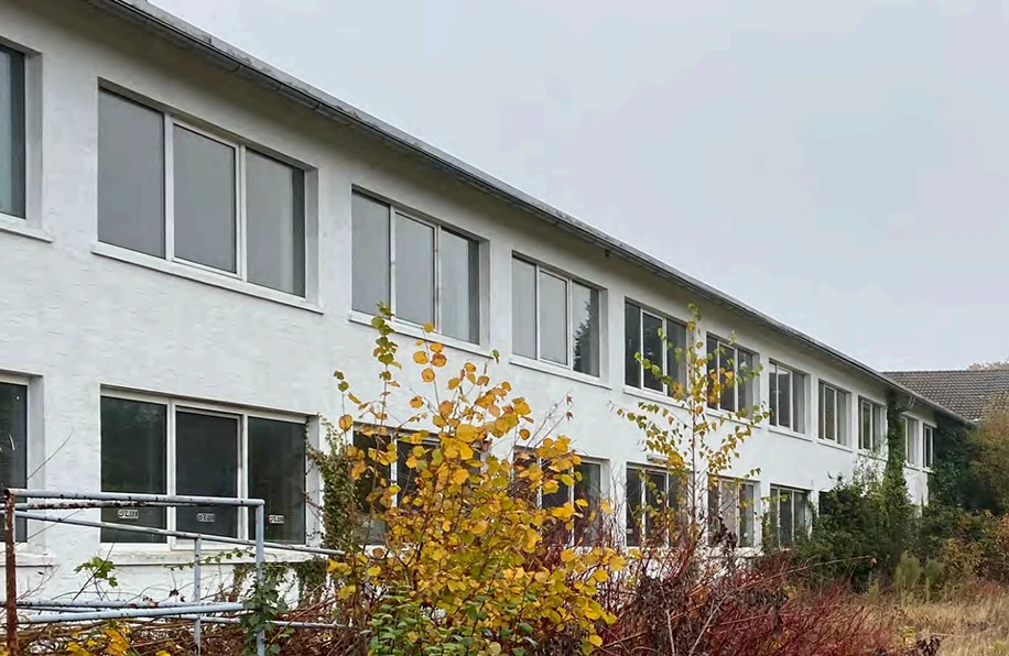 Isometrische Zeichnung eines Bauprojekts mit mehreren Gebäuden und markierten Strukturen in Rot