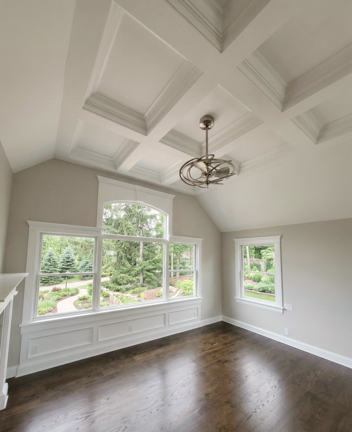 Custom millwork featuring coffered ceiling, detailed trim, and large windows in finished living space