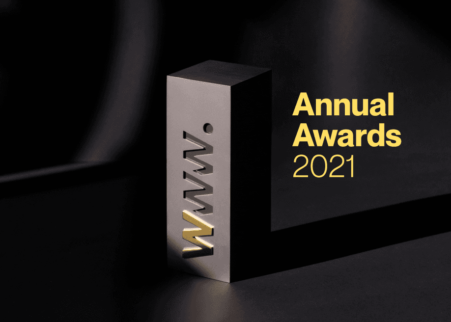 A sleek, metallic award with "WWW" cut out and highlighted in yellow sits on a dark surface. "Annual Awards 2021" is written in bold yellow text.