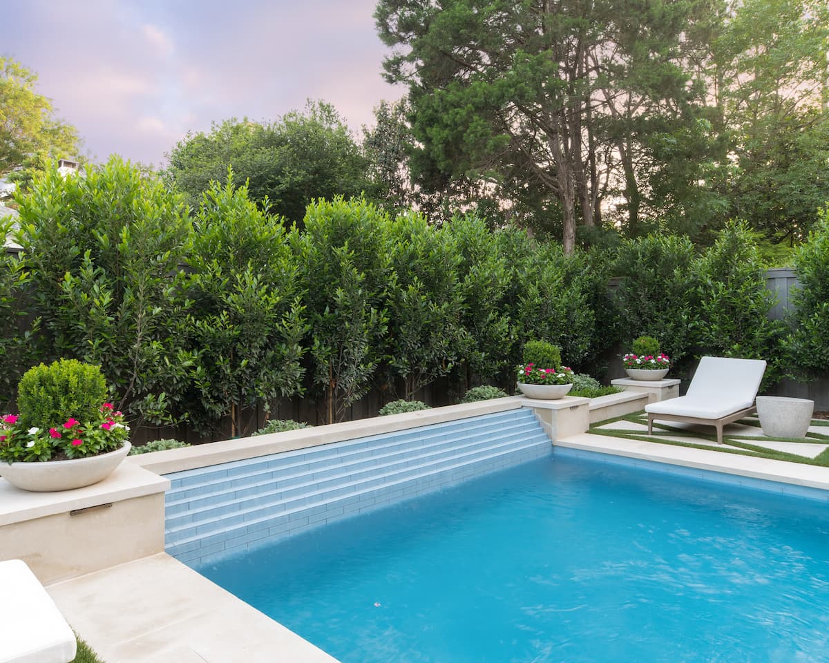 Geometric pool design detail with linear tile work and decorative planters showing layered privacy screening in Dallas