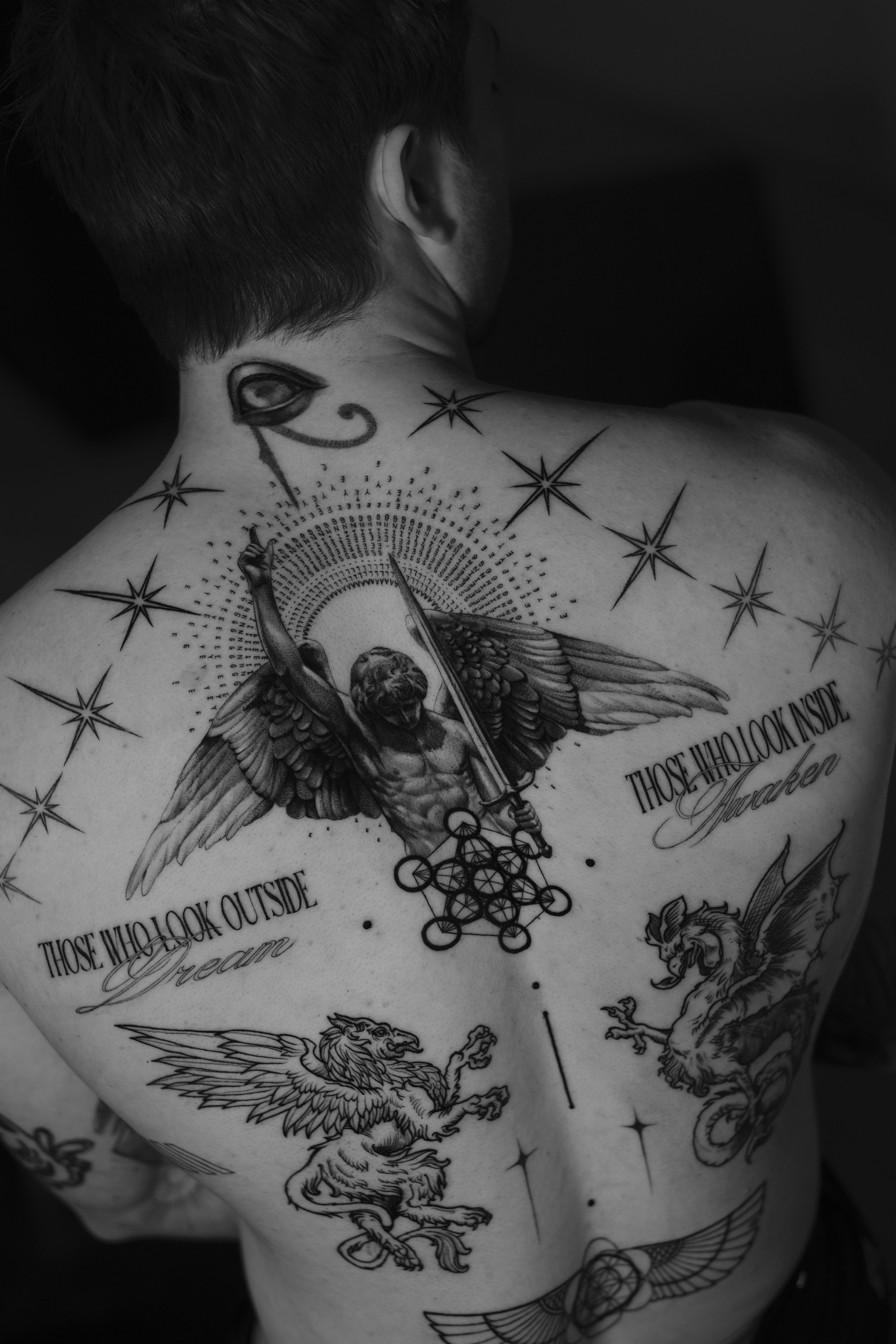 A woman observes framed black-and-white photographs in warm golden light