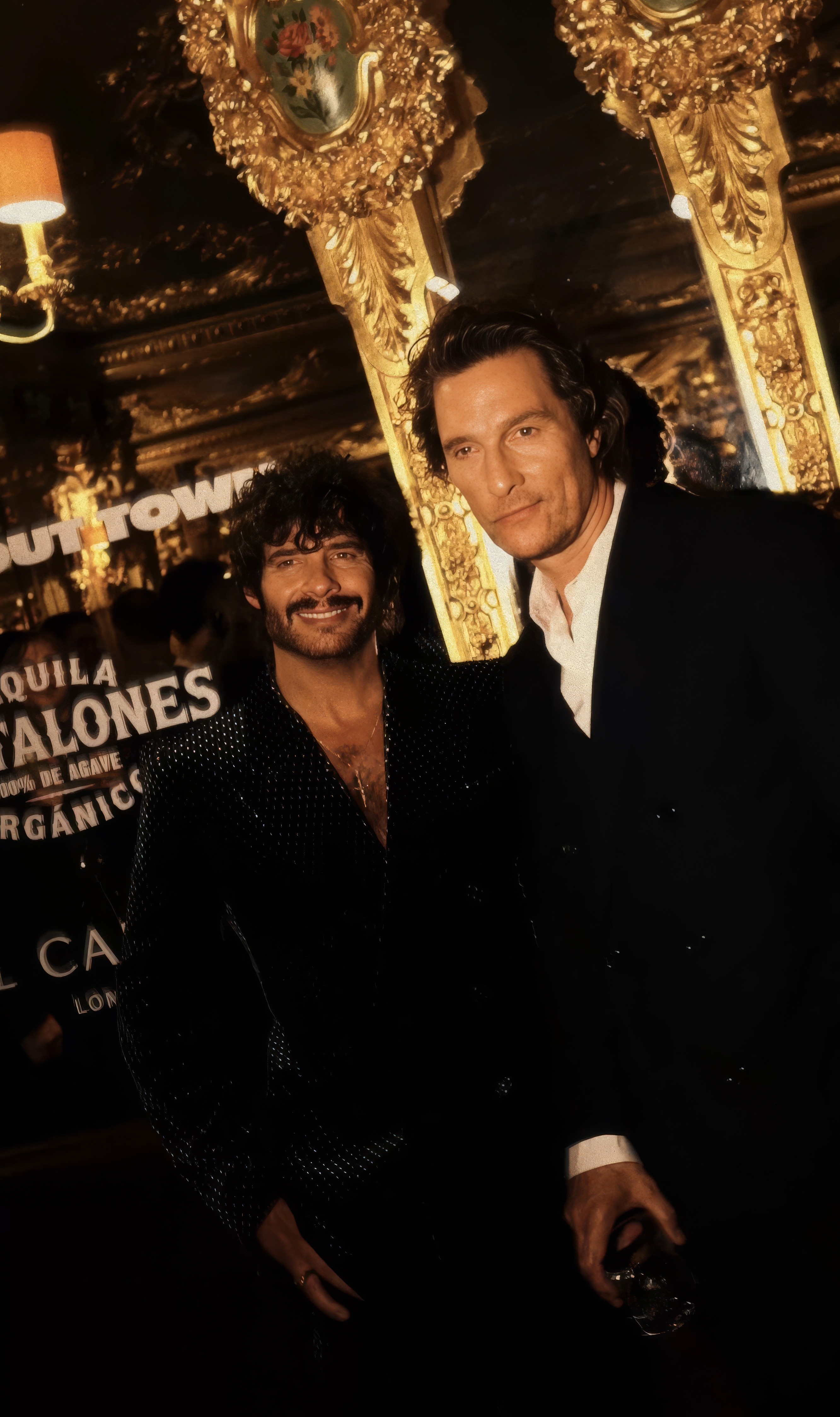 Bride sitting on ground against wall, groom standing nearby