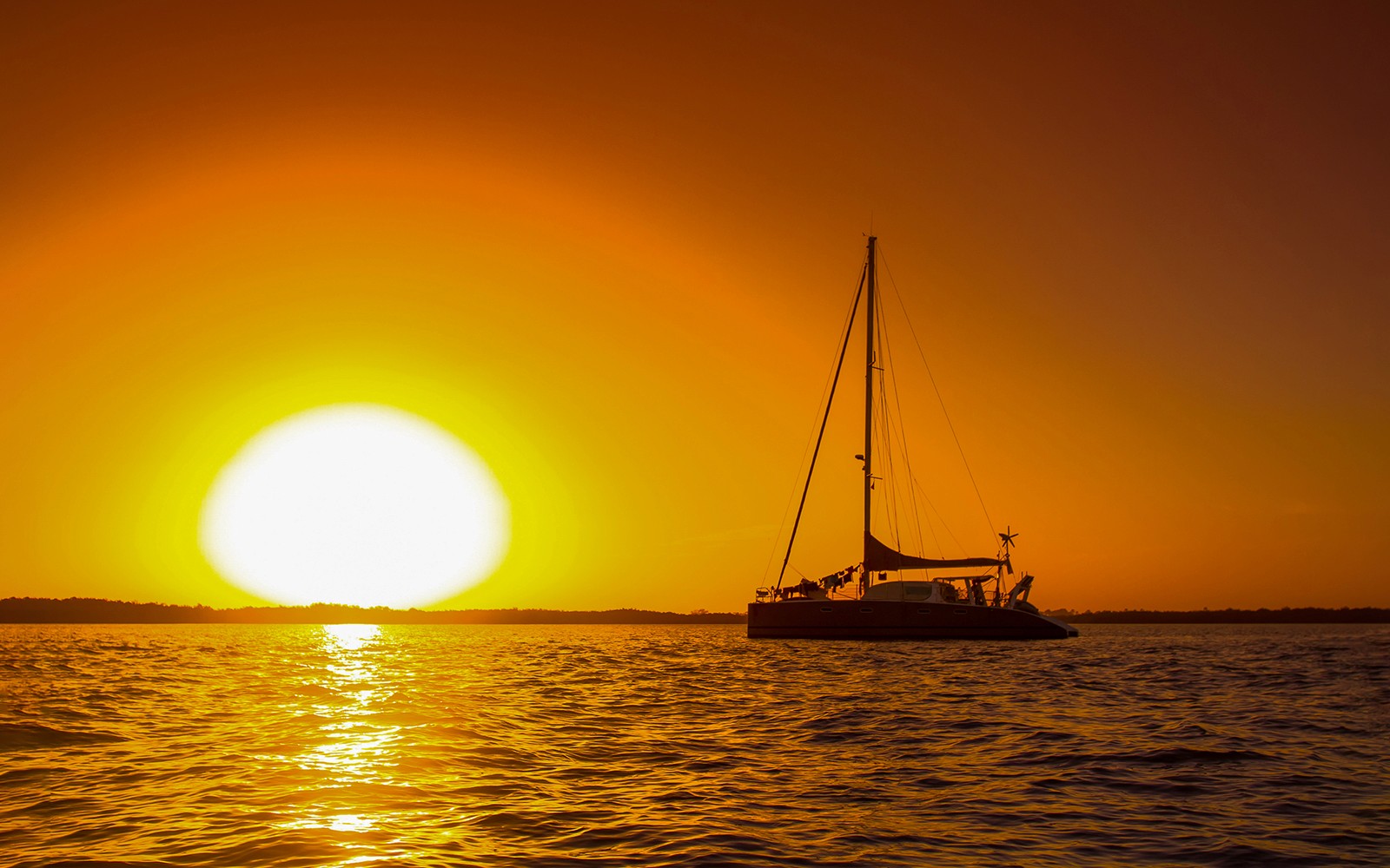 Catamaran sailing at sunset off the coast of Valencia.