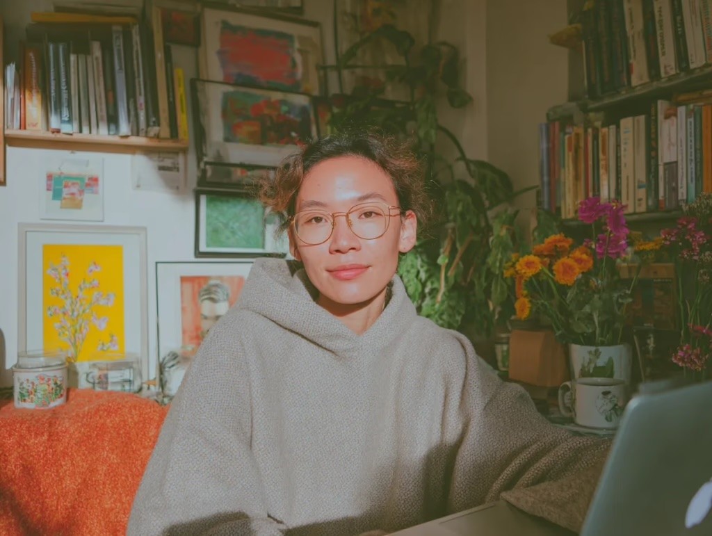 A person sits at a desk in a sunny office.