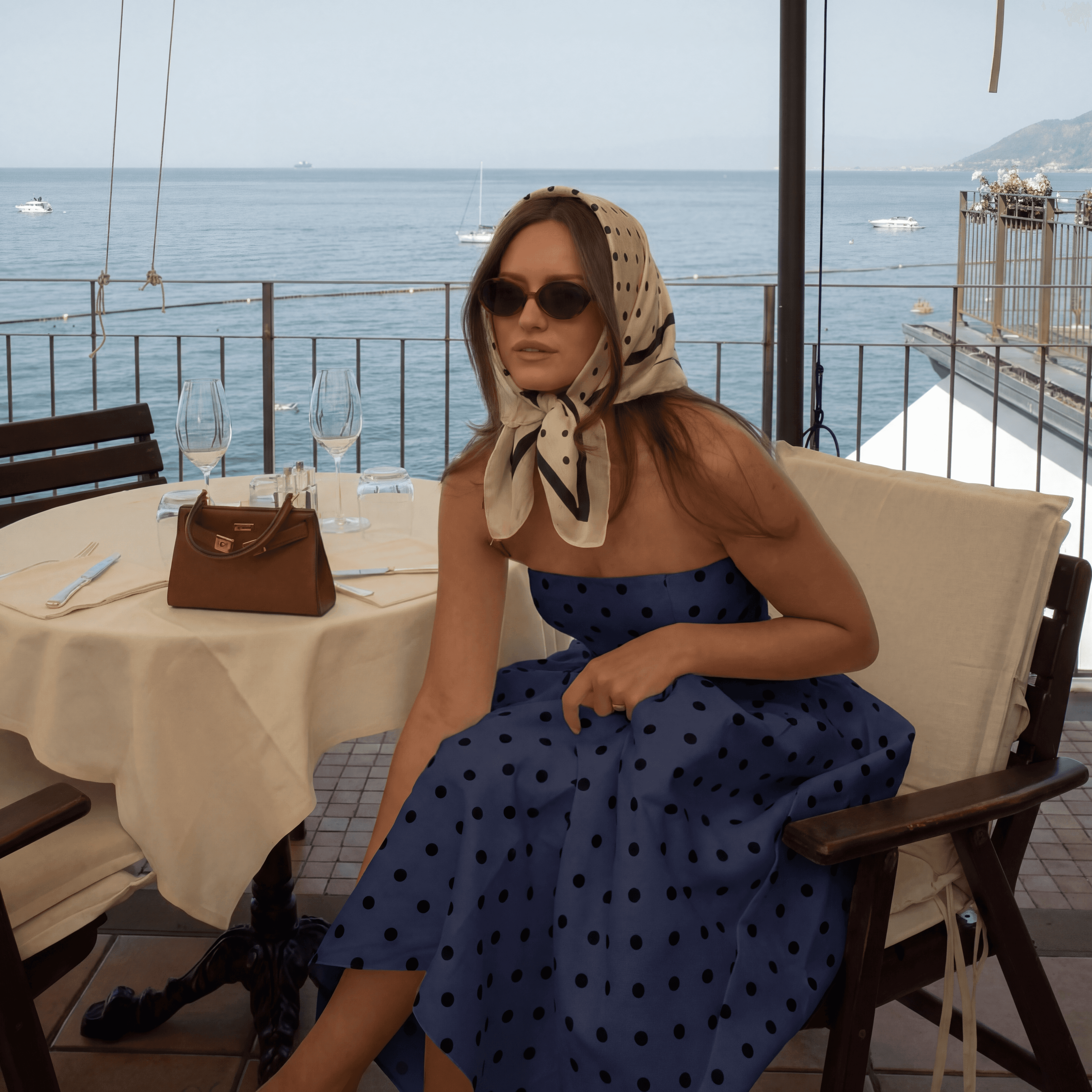 Group of hikers walking through a mountain meadow surrounded by pine trees and misty peaks.