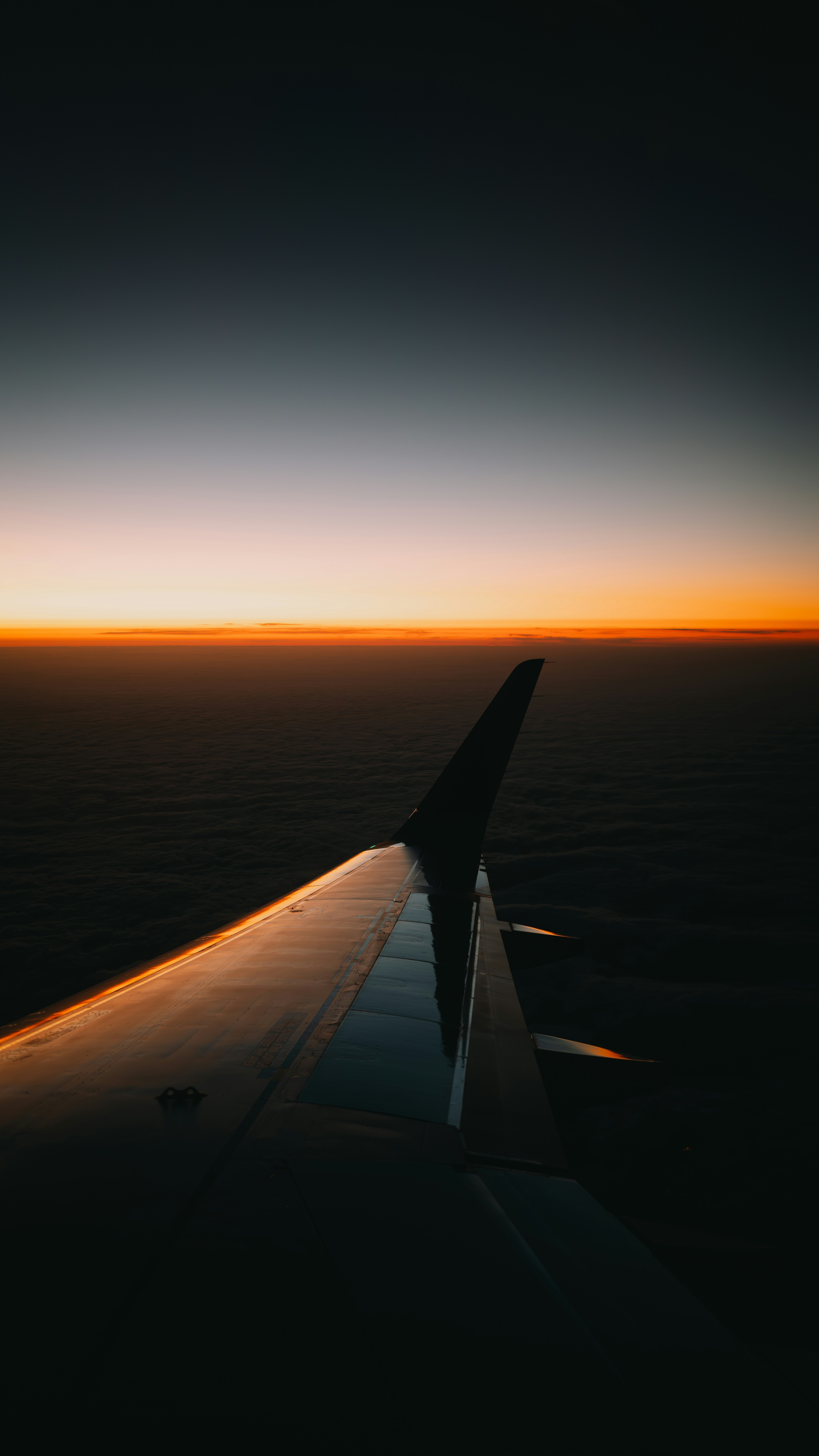 The wing of an airplane as the sun sets
