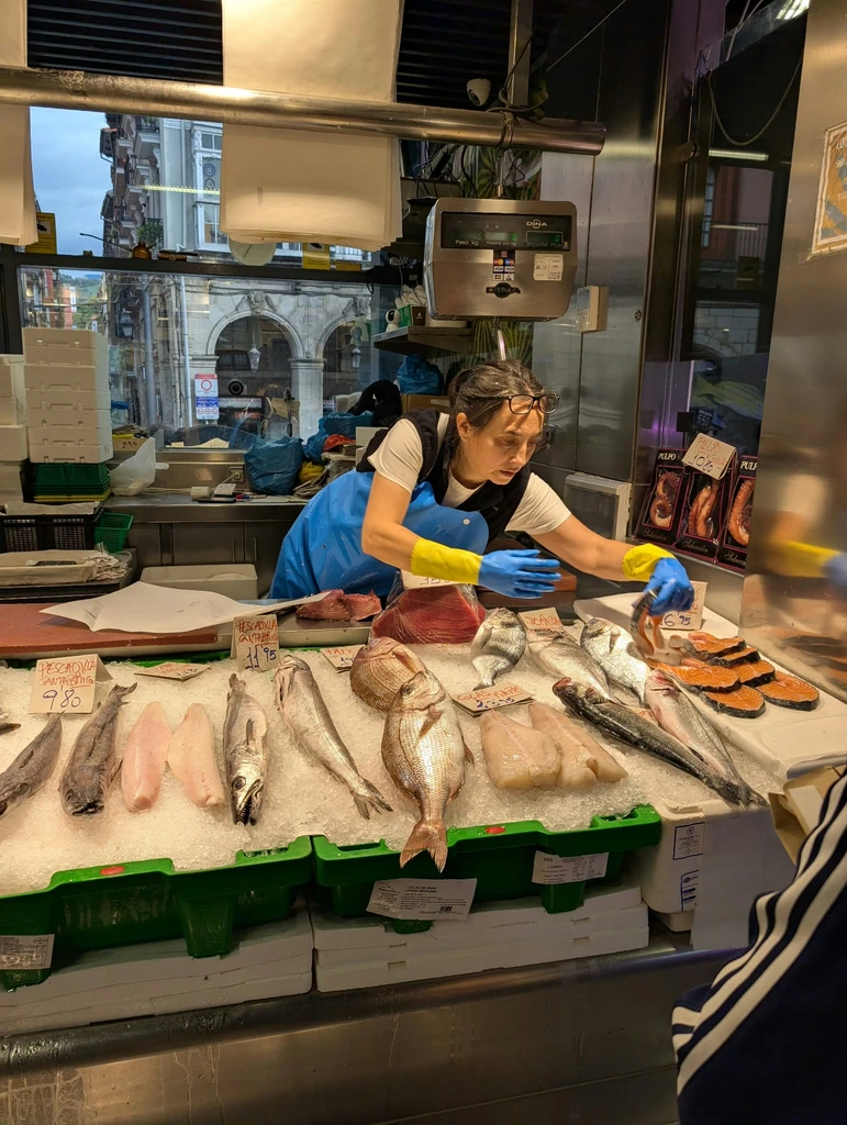 Fishmonger preparing fresh fish at a Basque market stall