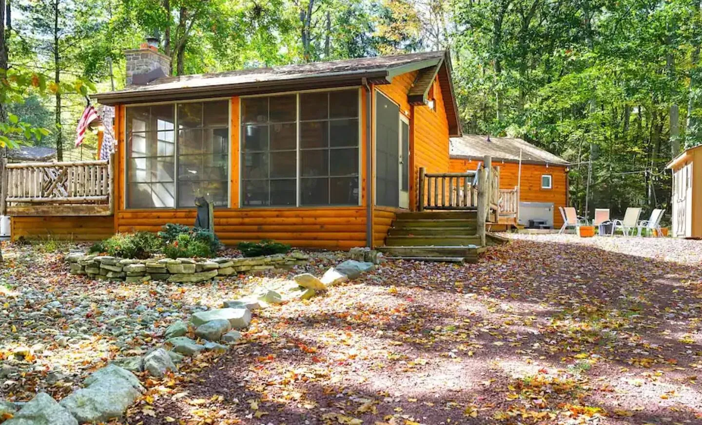 Log cabin with screened porch and deck among fall trees, Barefoot Bungalow, Lake Harmony, PA