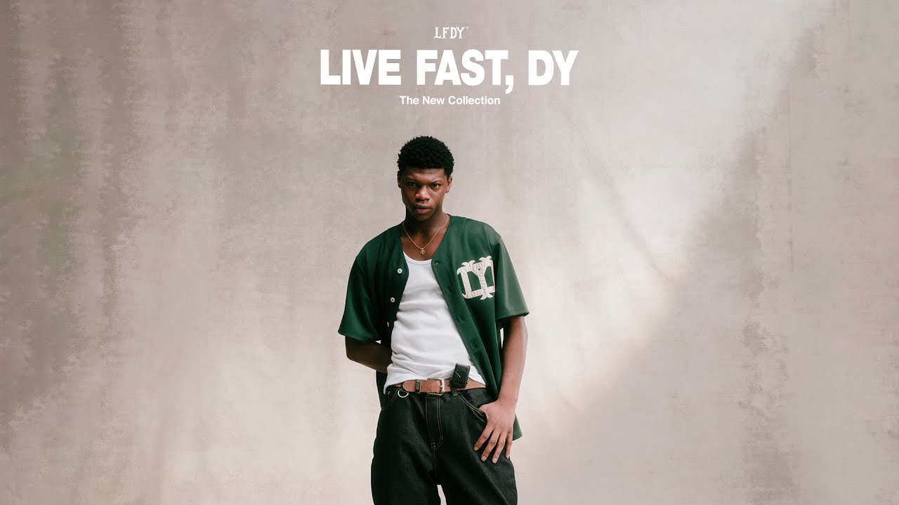 The image displays a modern and minimalist vinyl record player with a sleek design. The focal point is a large, shiny black vinyl disc with a vibrant orange label.