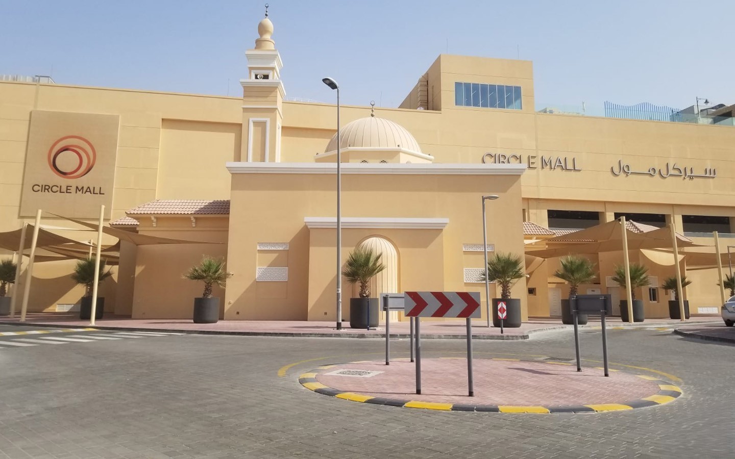 The Circle Mall in Jumeirah Village Circle, featuring a traditional beige mosque with a dome and minaret at its entrance.