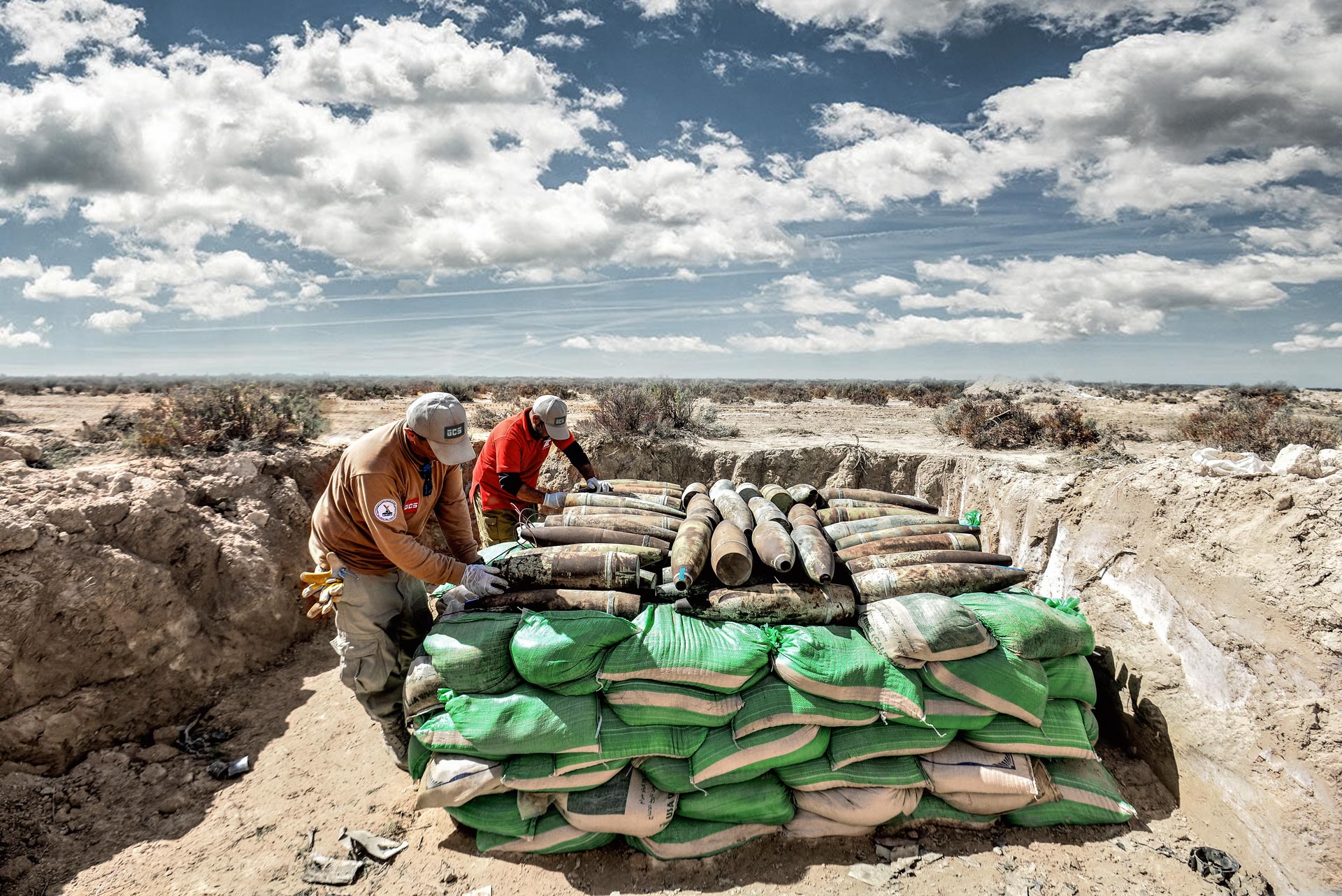 GCS EOD operators preparing collected artillery shells and UXO for controlled demolition in Libya.