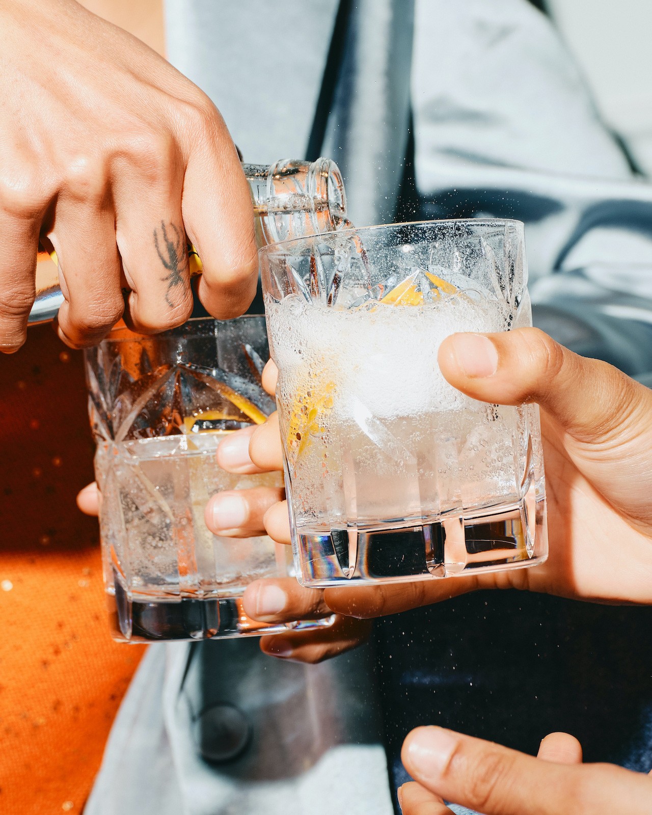 Close up of a drink being poured between friends