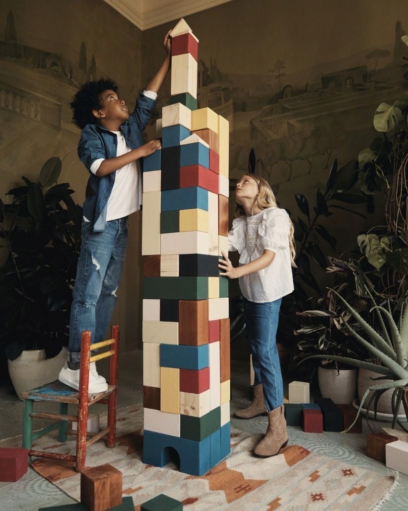 woman wearing grey striped dress shirt sitting down near brown wooden table in front of white laptop computer