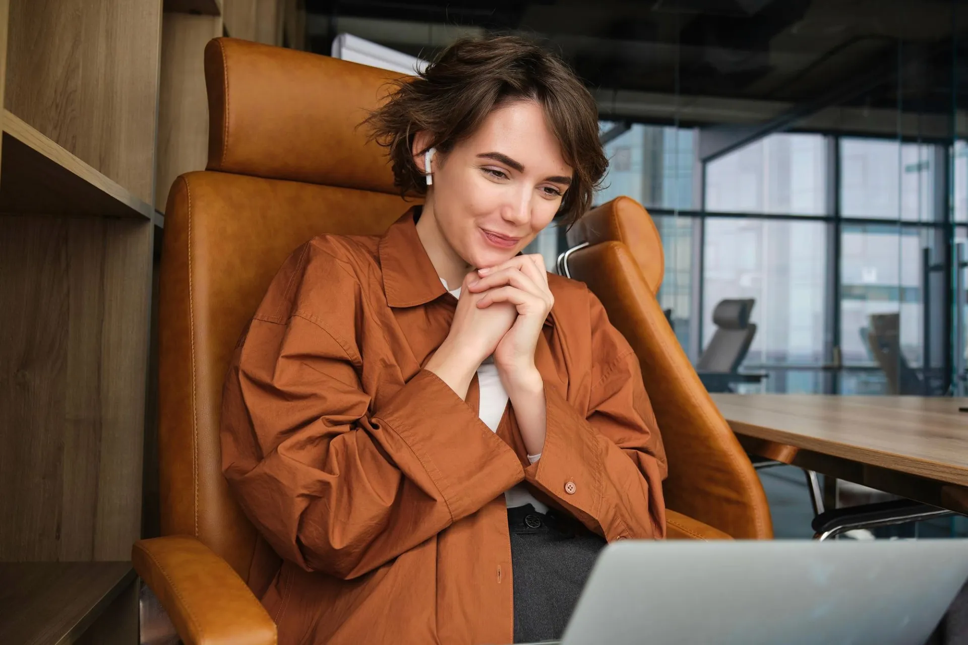 Person sitting in a chair with an open laptop and mouth wide.