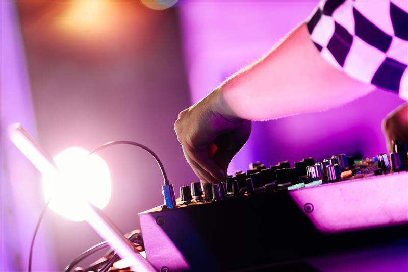 An image showing a DJ during a live event playing with audio-reactive visuals on his set.