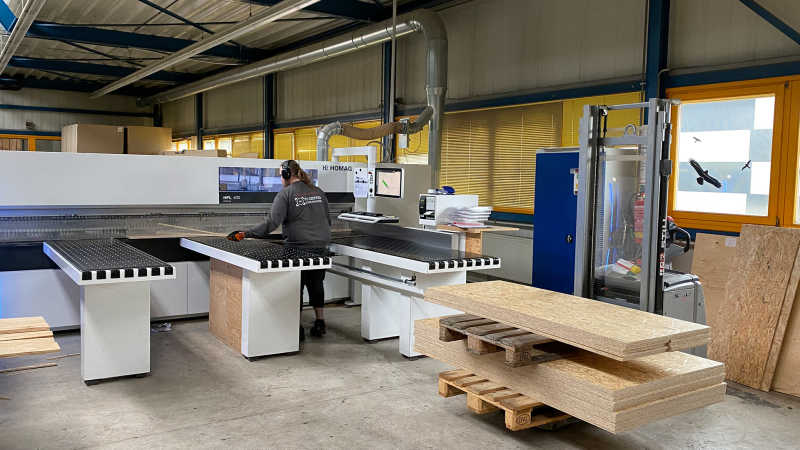 Carpenter at a panel dividing saw in a carpentry workshop