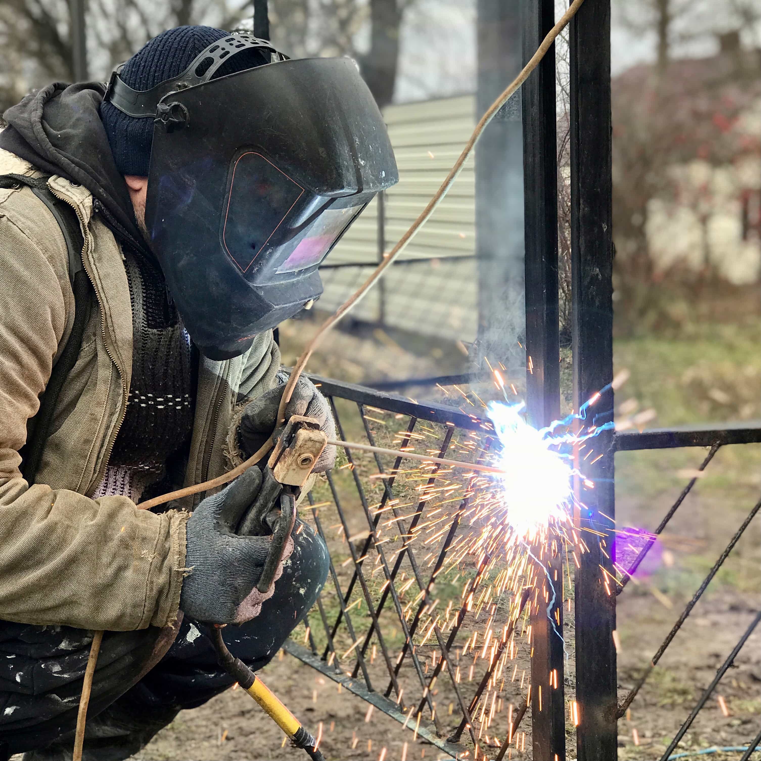 man in brown and black jacket holding white plastic bag