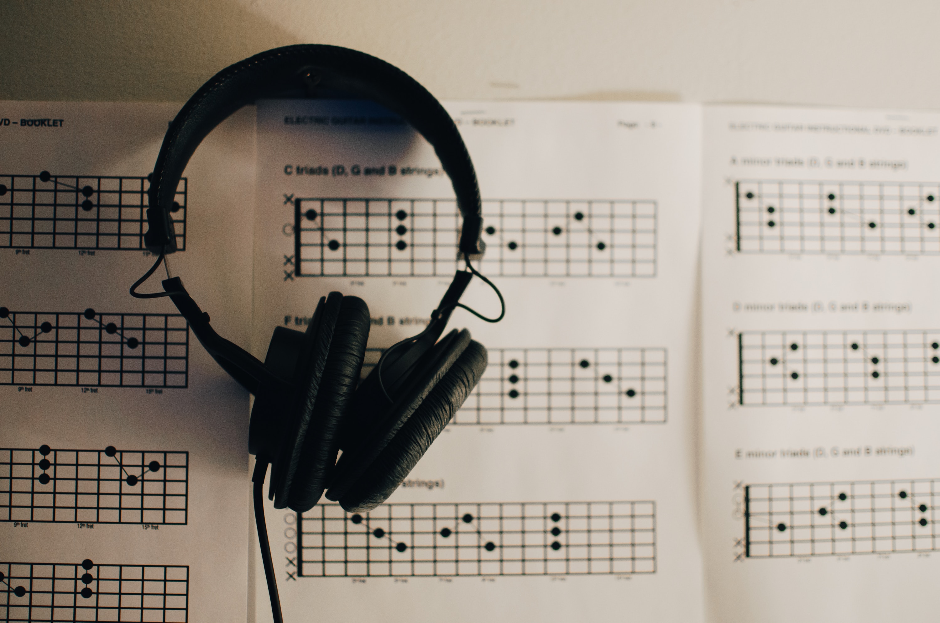 headphones over music book - how to create your own music 