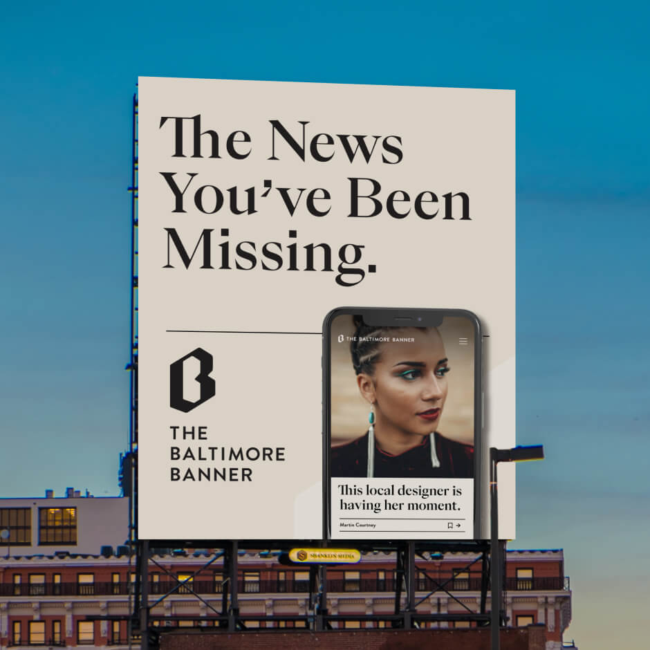 A billboard displays "The News You’ve Been Missing" with The Baltimore Banner logo and an image of a phone showing a news article featuring a woman.