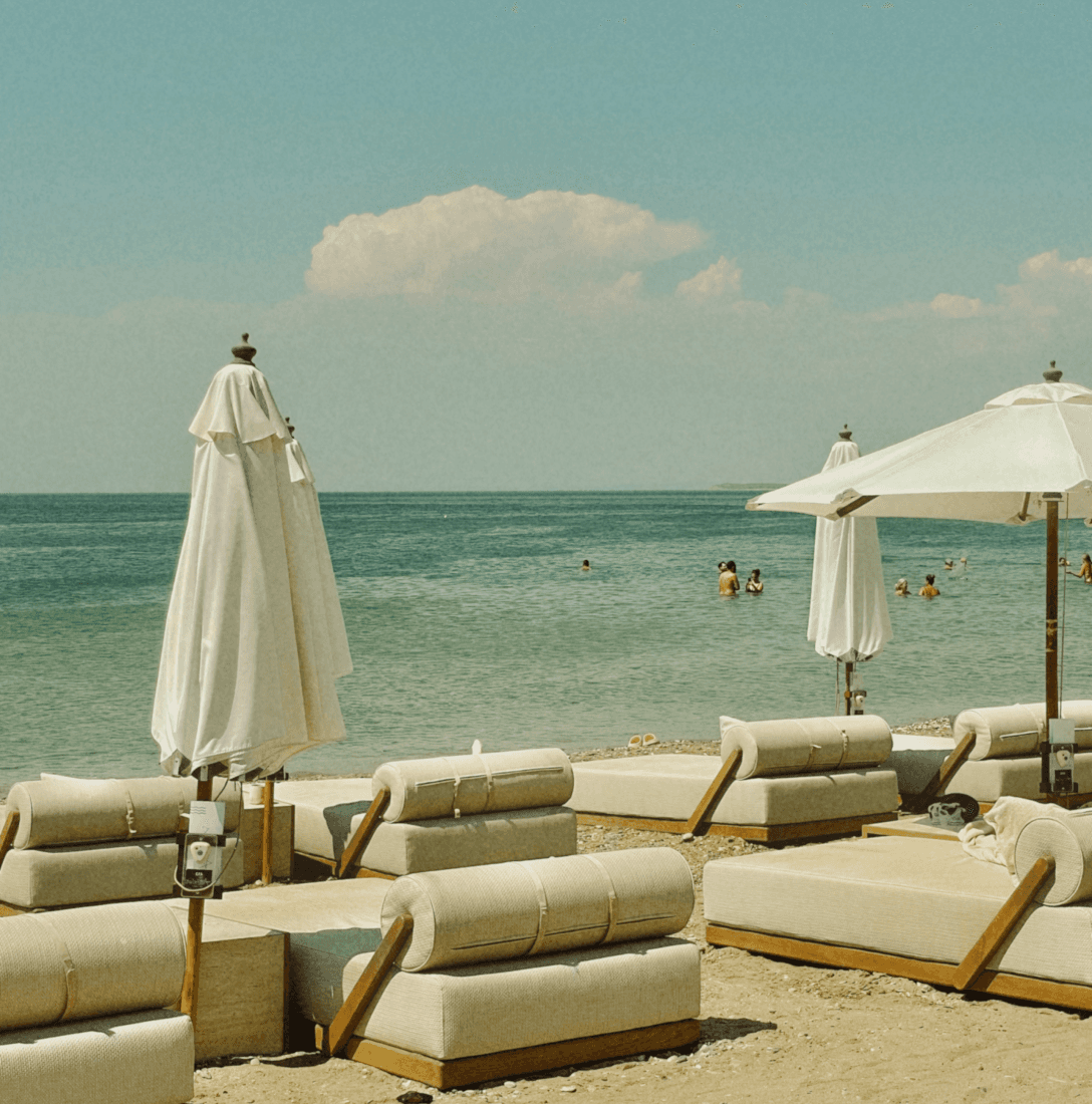 Transats de plage chic avec parasols blancs – univers hôtelier balnéaire raffiné